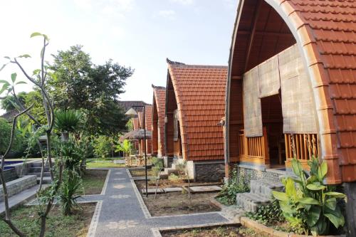 a row of houses with a pathway next to it at Kubu Padi Wooden House in Pemuteran