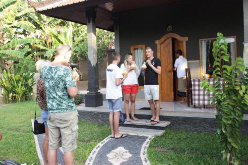 a group of people standing outside of a house at Kubu Padi Wooden House in Pemuteran