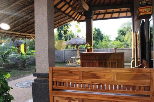 a wooden bench in front of a restaurant at Kubu Padi Wooden House in Pemuteran