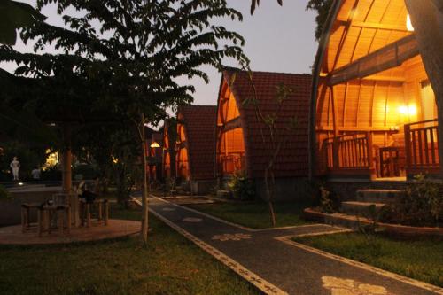 a night view of a building with the lights on at Kubu Padi Wooden House in Pemuteran
