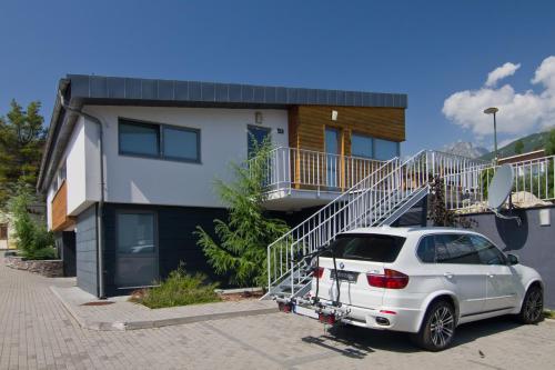 a white car parked in front of a house at Mountain Villas Polana in Smokovce