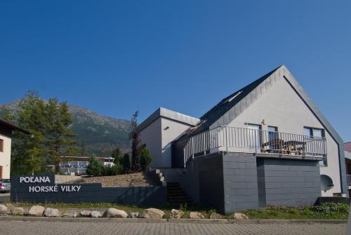 a house with a balcony on the side of it at Mountain Villas Polana in Smokovce