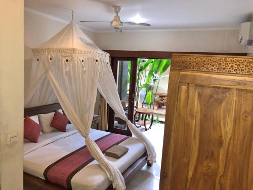 um quarto com uma cama de dossel em Umah Belos em Ubud