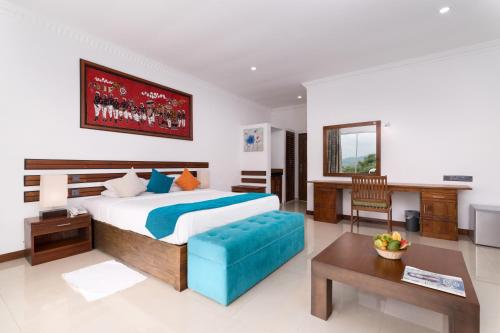 a bedroom with a large bed and a desk at Elegant Hotel in Kandy