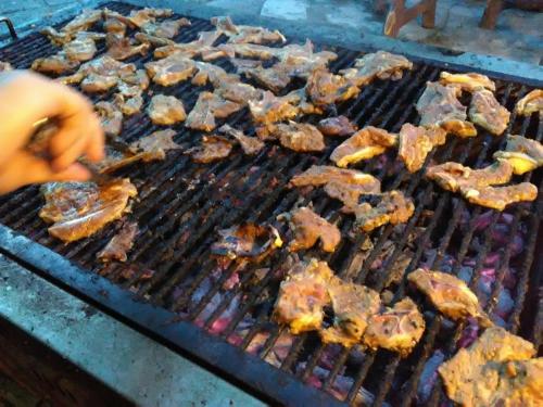 a bunch of meat cooking on a grill at Hotel Seri Malaysia Mersing in Mersing