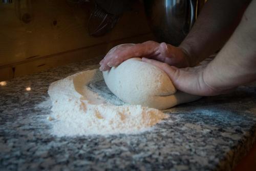 a person kneading a ball of dough on a counter at Le Rêve d'Aghon Chambres et Restaurant in Bagnères-de-Bigorre