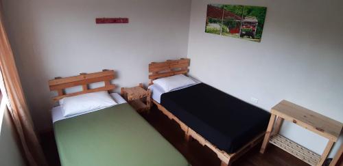 two twin beds in a room withthritisthritisthritisthritisthritisthritisthritisthritisthritis at Hostal Triangulo del Café in Manizales