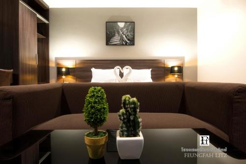 a living room with a couch and a bed at Feungfah Litz in Phetchabun