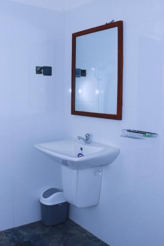 a bathroom with a white sink and a mirror at Talalla 170 Villa in Talalla