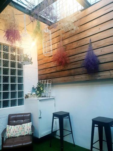a room with two stools and a wooden wall at Tainan Little Day in Tainan
