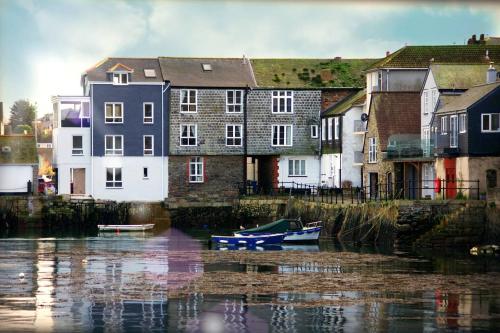 a group of buildings next to a river with a boat at The Old Quayside House in Falmouth