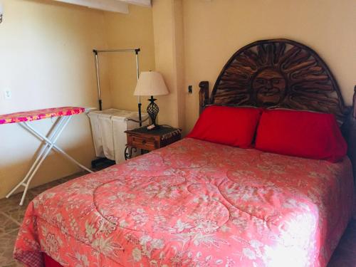 a bedroom with a large bed with red pillows at Ocean Front Baja Vacation in Rosarito