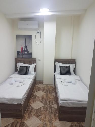 twee bedden in een kamer met witte muren bij Green Palma in Koetaisi