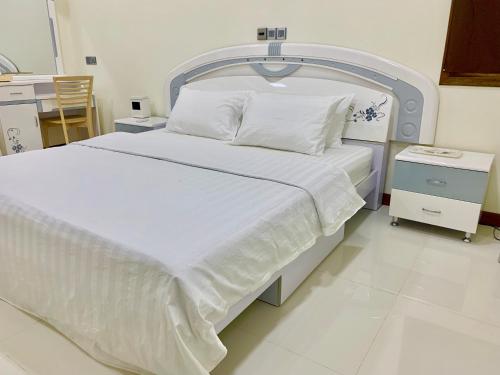 a bed in a hospital room with white sheets and pillows at Endhaa, Divers Home in Fuvahmulah