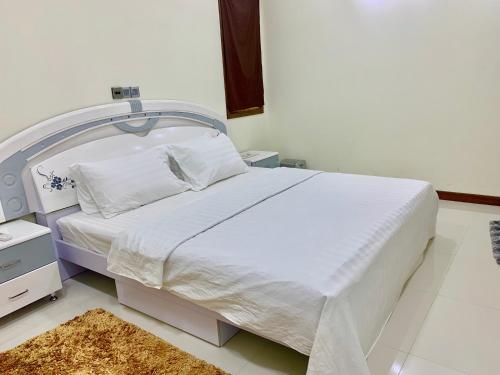 a bedroom with a bed with a white bed frame at Endhaa, Divers Home in Fuvahmulah