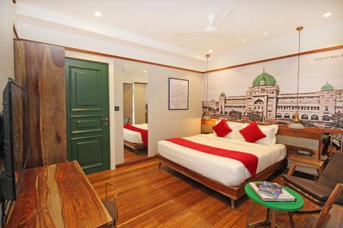 a bedroom with a bed and a desk and a tv at Theory9 Premium Service Apartments Khar in Mumbai