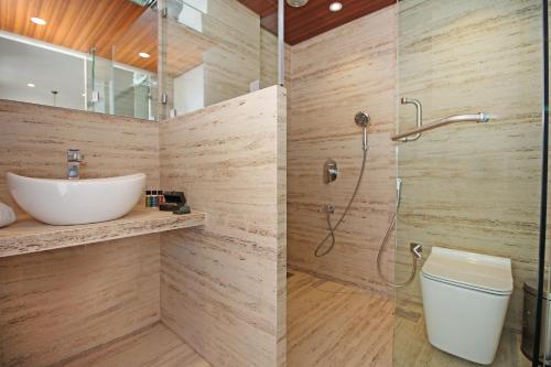 a bathroom with a shower and a toilet and a sink at Theory9 Premium Service Apartments Khar in Mumbai