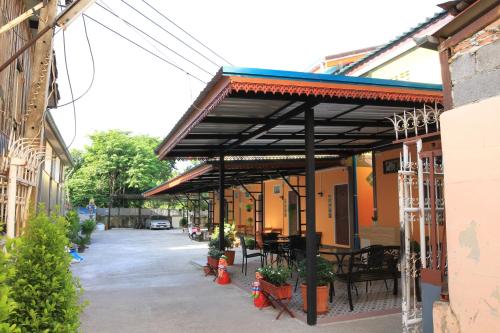 a patio with awning on a building with plants at Siri Guesthouse in Phra Nakhon Si Ayutthaya