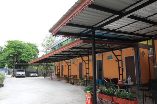 a building with awning over a parking lot with cars at Siri Guesthouse in Phra Nakhon Si Ayutthaya