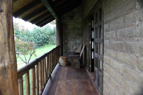an outside porch of a stone building with a bench at La Tierra Grande in Zacatlán