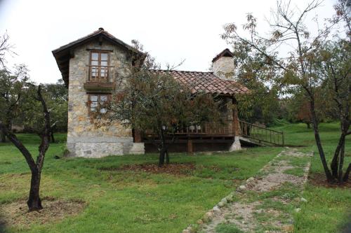 a small stone house with a porch in a field at La Tierra Grande in Zacatlán