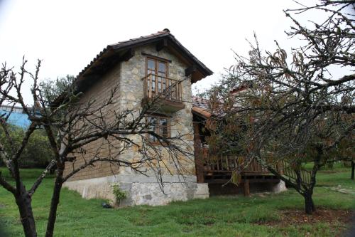 a stone house with a wooden deck in a field at La Tierra Grande in Zacatlán