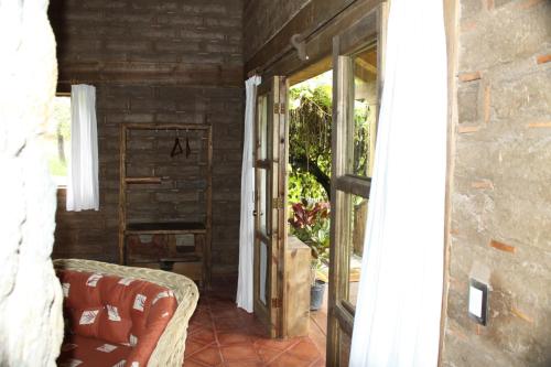 an open door to a patio with a chair and a window at La Tierra Grande in Zacatlán