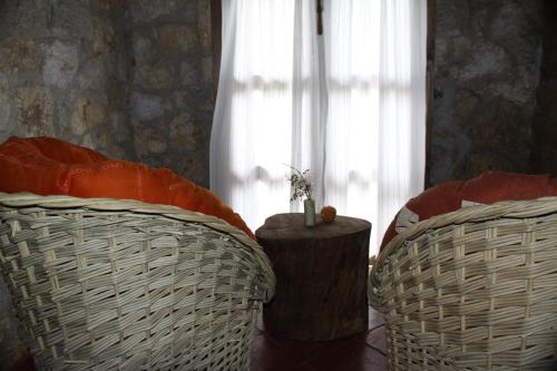 two wicker chairs and a table in front of a window at La Tierra Grande in Zacatlán