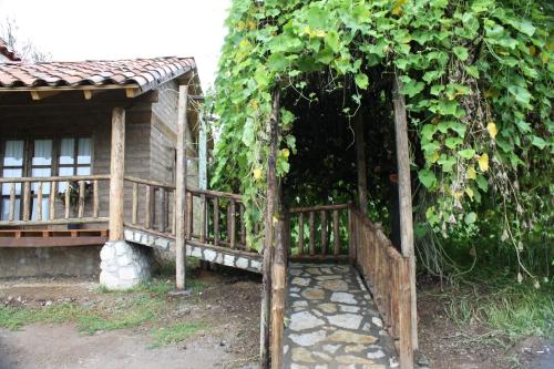 a wooden fence next to a house with a tree at La Tierra Grande in Zacatlán