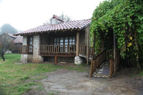 a small house with a porch and a fence at La Tierra Grande in Zacatlán