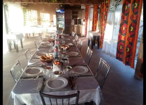 una mesa larga con platos de comida. en Inn Sogdiana, en Panjakent