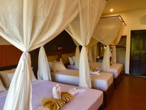 a room with four beds with people laying on them at Villa Dika Pemuteran in Pemuteran