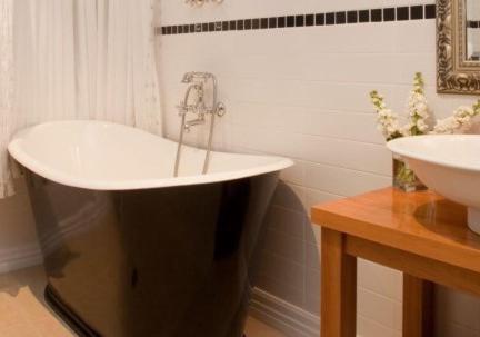 een badkamer met een wastafel en een ligbad bij Charming Wanaka Cottage in Wanaka