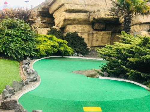 a pool of green water in front of a mountain at Ingoldmells, The Grange Holiday Park 3-Bedroom Caravan in Skegness