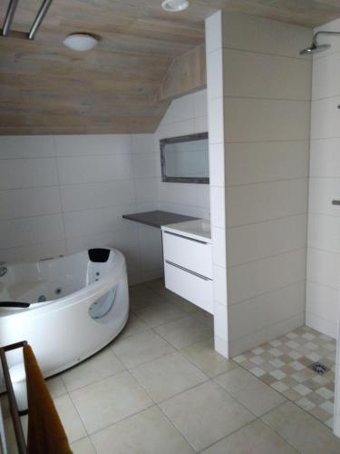 a bathroom with a tub and a sink at Vakantiewoning EL COULEYE in Durbuy