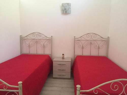 two beds sitting next to each other in a bedroom at Green space in Giurdignano