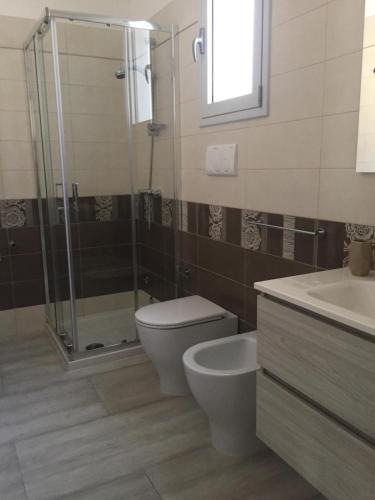a bathroom with a toilet and a shower and a sink at Green space in Giurdignano