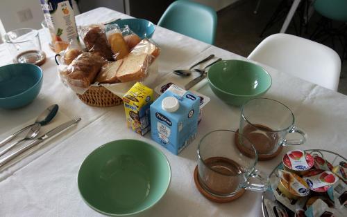 a table with bowls and cups and bread on it at Il Cavaliere Bed and Breakfast in Caserta