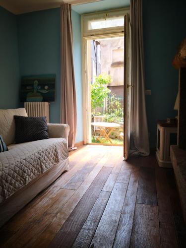 a living room with a couch and a sliding glass door at Residenza Se son Rose in Schignano