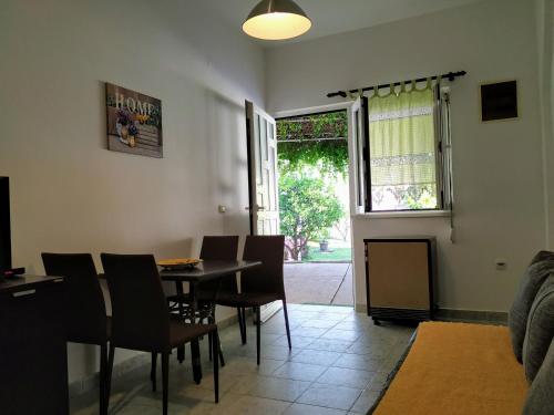 a dining room with a table and chairs and a window at Rooms & Apartments Vukasović in Kotor