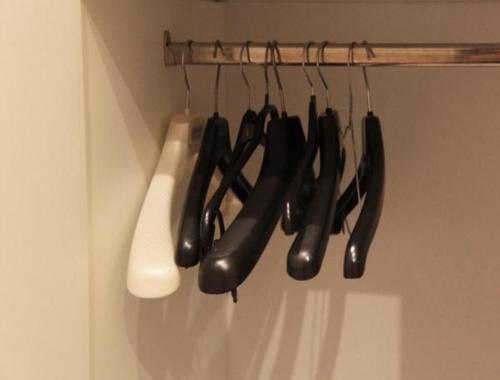 a bunch of black cooking utensils hanging on a rack at Athens Psiri Hotel in Athens