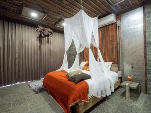 a bedroom with a bed with a mosquito net at Octopus Villas in Tejakula