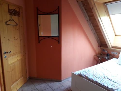 Cette chambre dispose d'une porte rouge et d'une fenêtre. dans l'établissement Gästezimmer in traumhafter Lage neben der Kurstadt, à Oberthulba