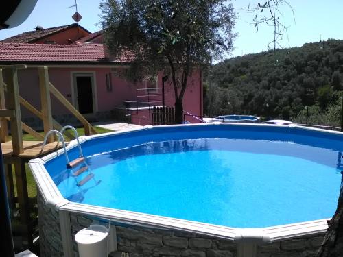 a large swimming pool in a yard with a house at Fior d'olivo - Villa con piscina privata a pochi minuti dal centro di Sestri Levante, mare e spiaggie in Santo Stefano del Ponte