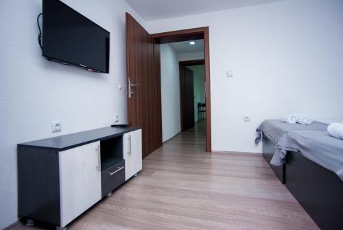 a room with a bed and a television on a wall at Vila Magdalena in Gevgelija