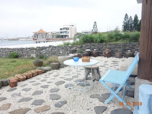 a table and two chairs on a patio with the beach at Ocean Sky B&B in Huxi