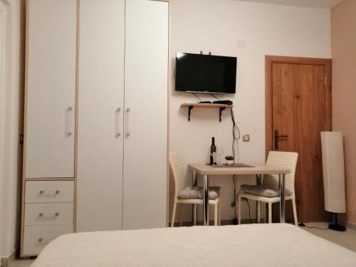 a bedroom with a bed and a desk with a television at Studio Apartman Irena1 in Bijela