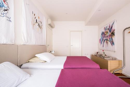 a bedroom with two beds with pink sheets at The Jasmine Terrace Retreat in Bologna