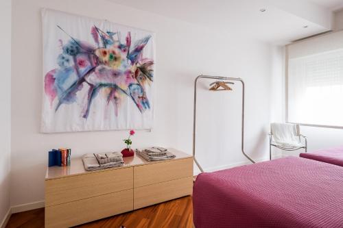 a bedroom with a bed and a dresser and a painting at The Jasmine Terrace Retreat in Bologna