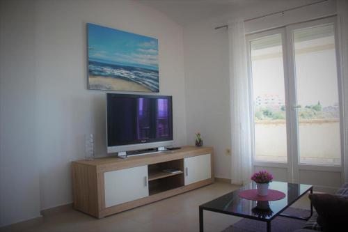 sala de estar con TV de pantalla plana en un centro de entretenimiento en Apartment Donat, en Zadar